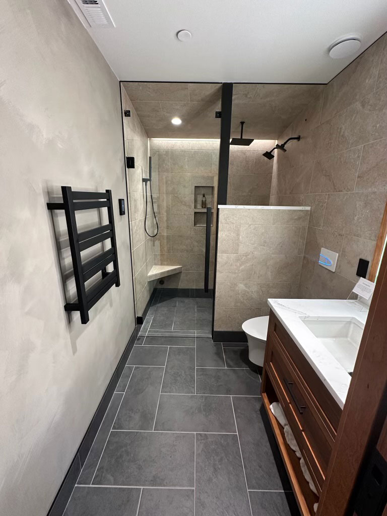 Large format slate floor tile and walk-in shower masonry in a luxury bathroom.