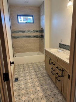 Master Suite Tile Master bathroom featuring patterned floor tile and a custom-tiled tub surround.