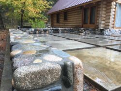 Stone Veneer & Wainscoting Natural stone wainscoting and veneer on a luxury log home exterior.